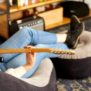 Person relaxing and playing guitar on the inflatable seat with foot rest